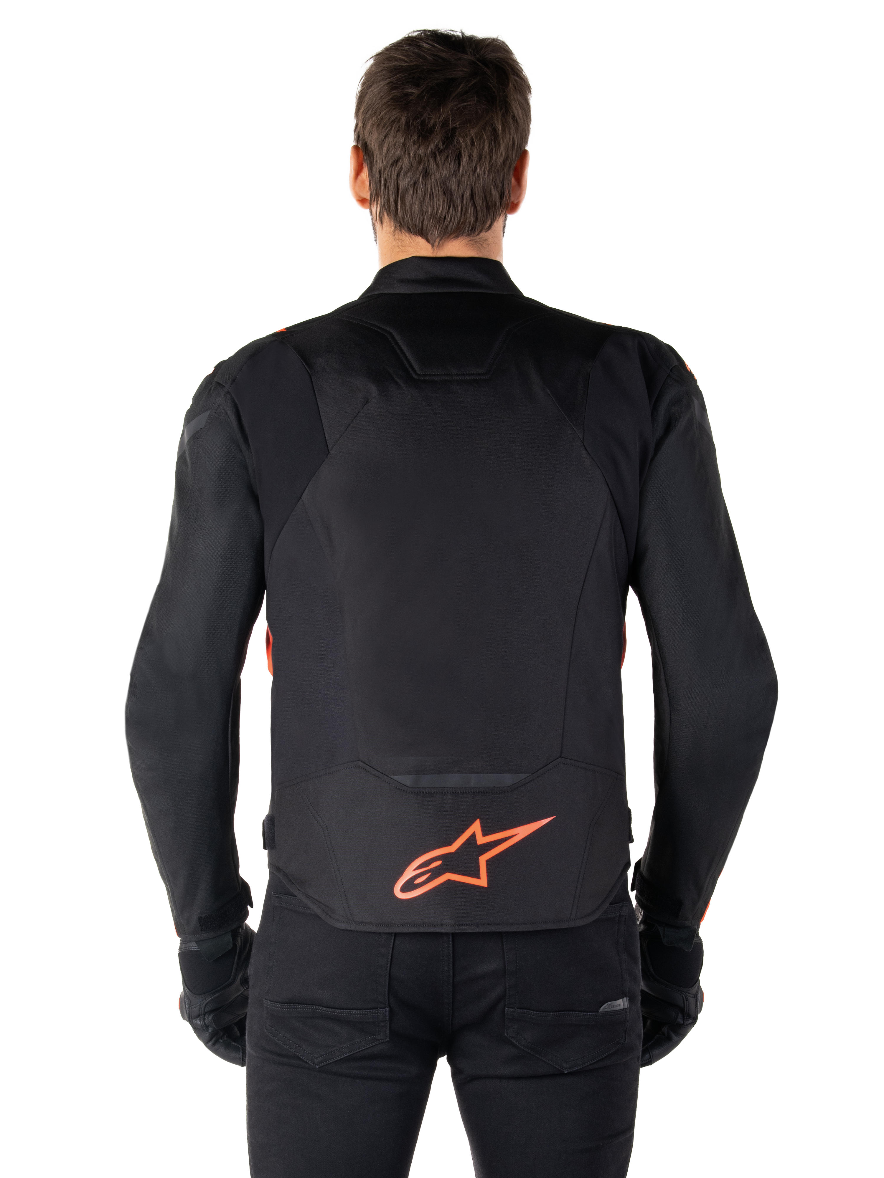 Casaco Alpinestars T-Jaws V4 Waterproof, vista traseira, preto com vermelho fluo, com um logótipo Alpinestars vermelho na parte inferior das costas, construção em tecido técnico, usado com calças e luvas pretas para um visual de condução desportivo completo