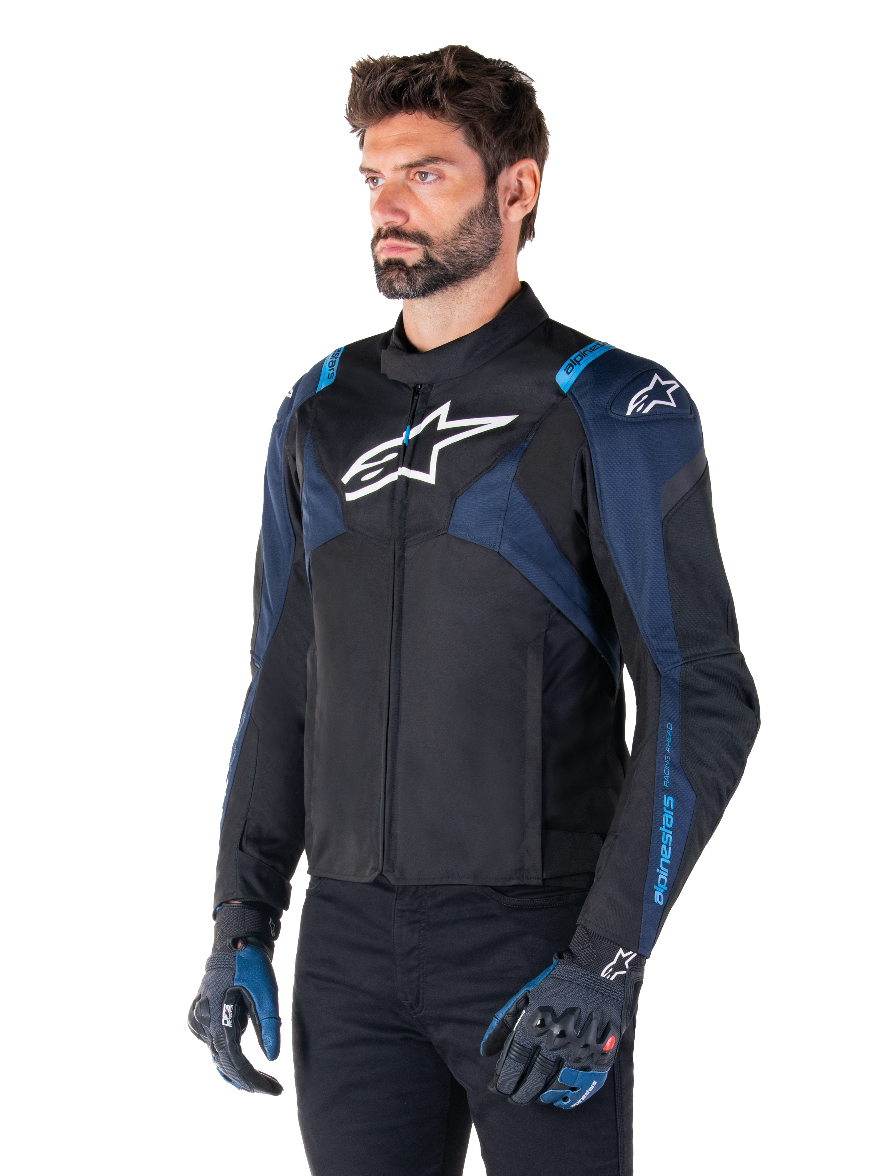 Casaco Impermeável Alpinestars T-Jaws V4, casaco de motociclismo, preto, azul escuro e azul Blithe, usado por um modelo com luvas a combinar e calças pretas, com logótipos Alpinestars brancos no peito e ombros e detalhes azuis nas mangas, equipamento têxtil desportivo