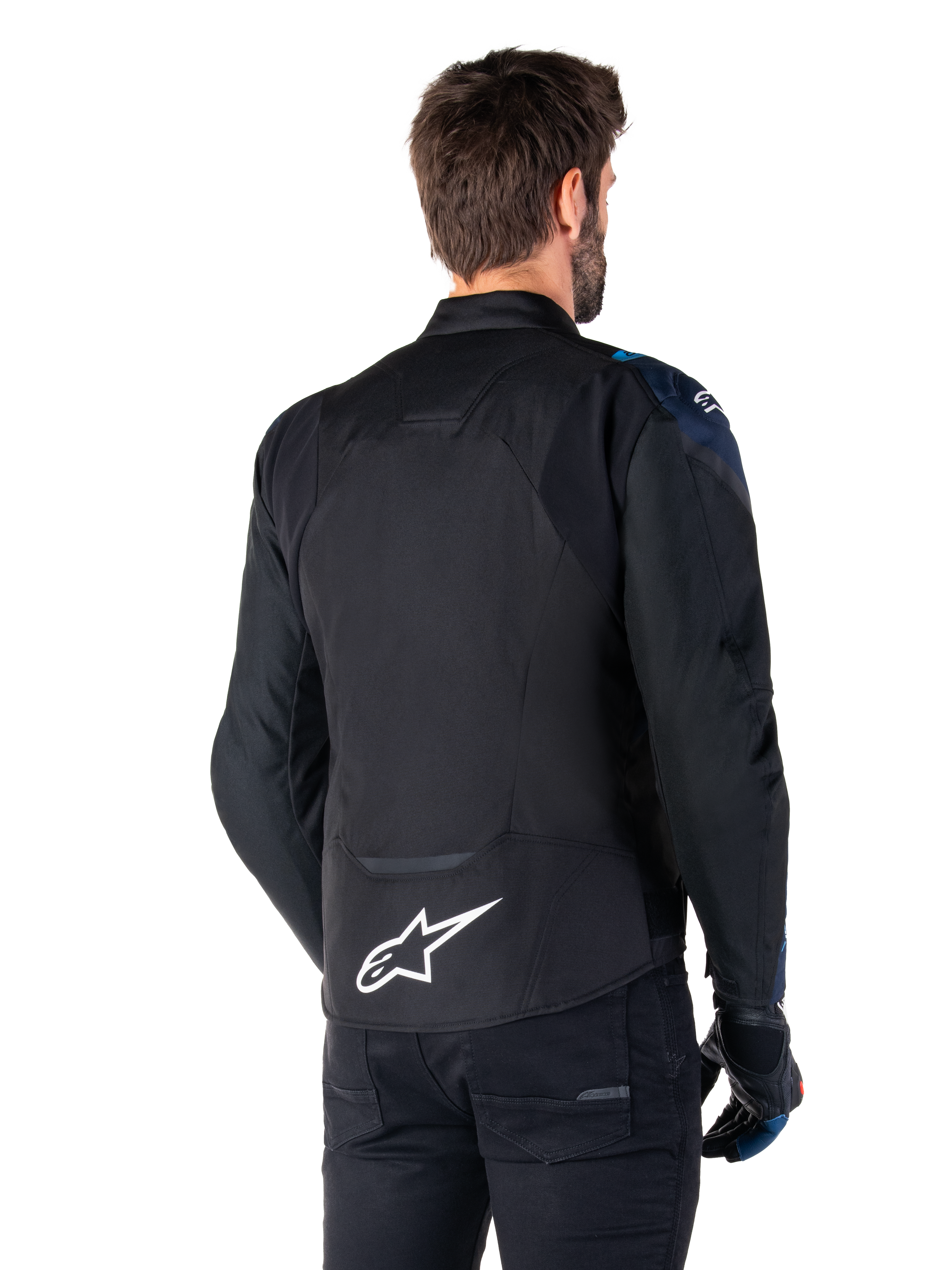 Casaco Impermeável Alpinestars T-Jaws V4, vista traseira, preto com detalhes em azul escuro e azul Blithe, logótipo de estrela branca na parte inferior das costas, silhueta desportiva, usado com calças pretas e luvas de motociclismo