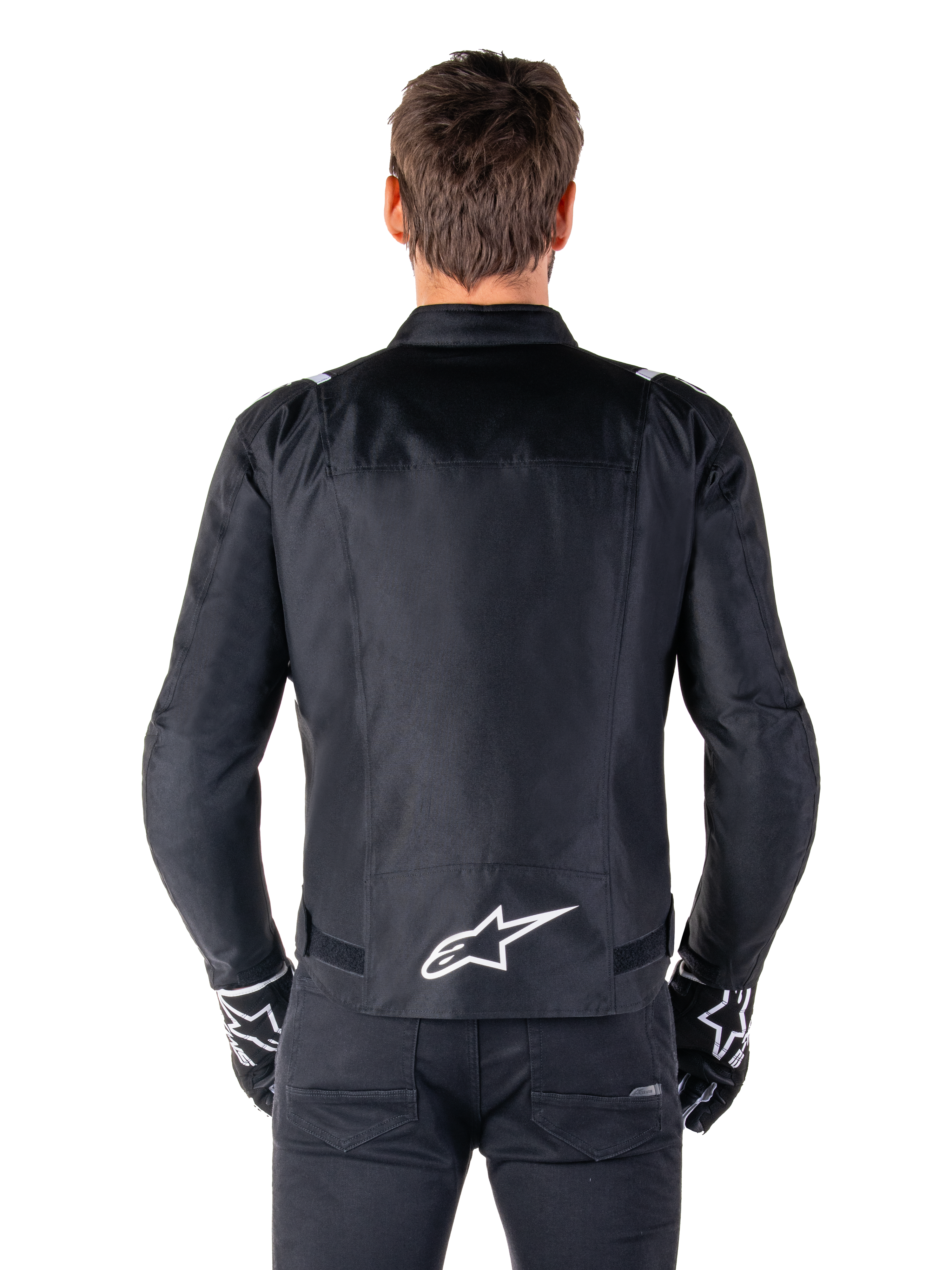 Alpinestars T-SPS V2 Waterproof Jacket, Black and White, back view showing white Alpinestars logo on lower back, worn with black pants and gloves, sport cut textile motorcycle jacket