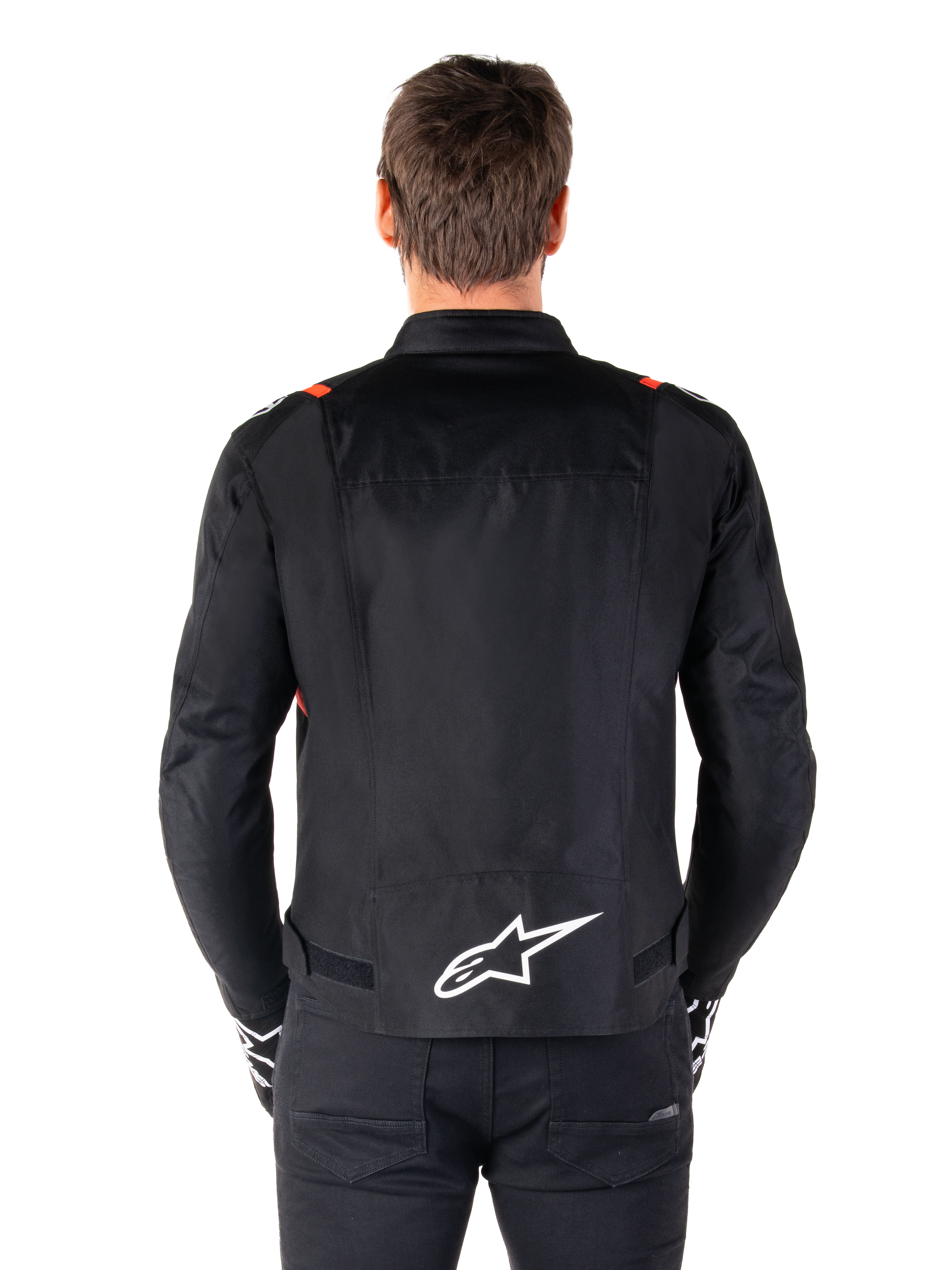 Alpinestars T-SPS V2 Waterproof Jacket, Black with White and Red Fluo accents, rear view featuring a large white Alpinestars logo on the lower back, sport cut textile motorcycle jacket, worn with black pants and gloves