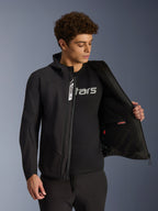Alpinestars Aeroshell Waterproof Jacket, Black softshell motorcycle jacket, unzipped showing interior pocket and lining, worn by a male model with a black logo tee, hooded design for casual urban riding and street style.
