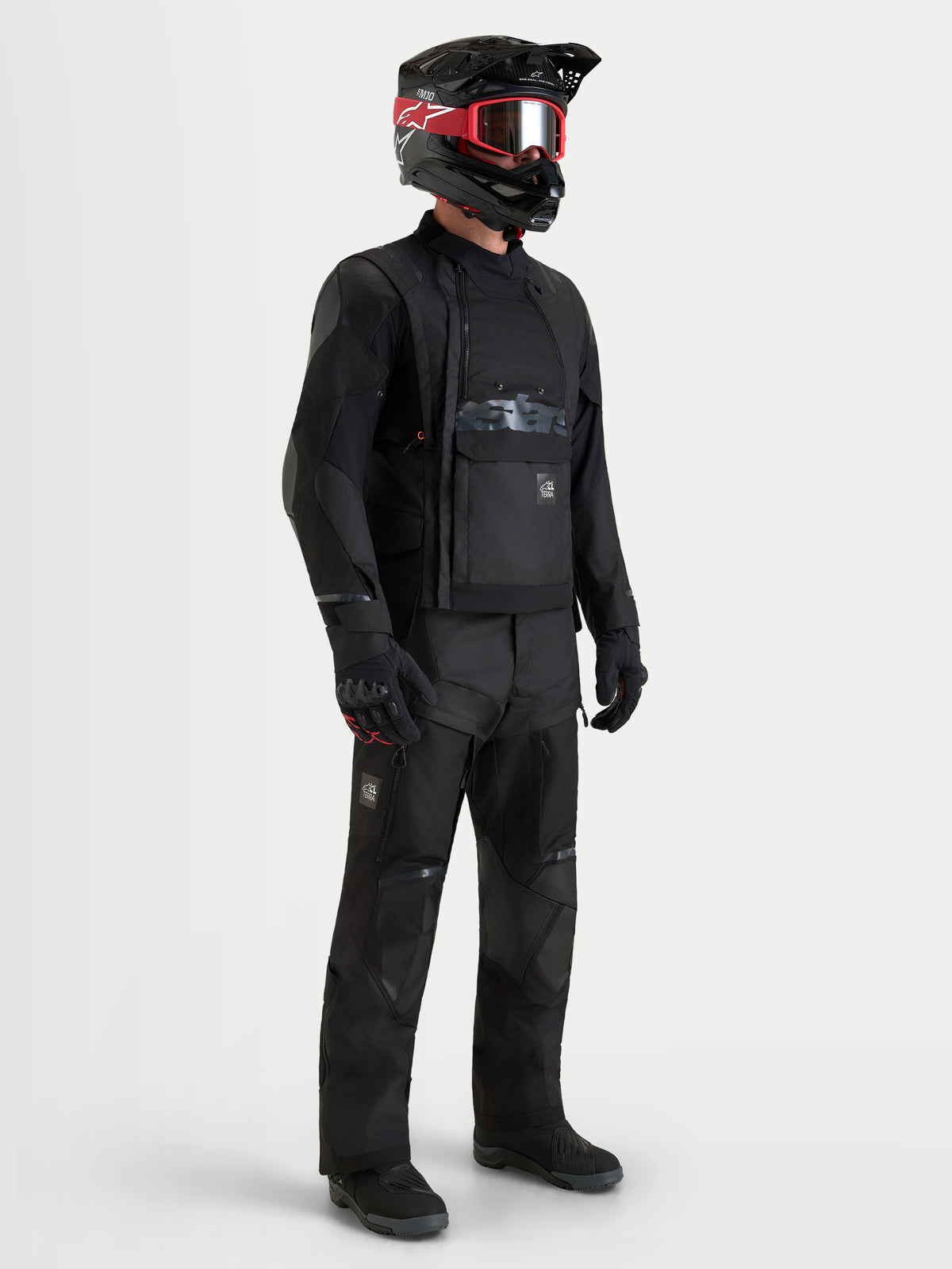 Alpinestars Harok V2 Drystar gear set, equipamento de moto adventure incluindo casaco e calças em preto, num modelo com capacete e óculos a condizer