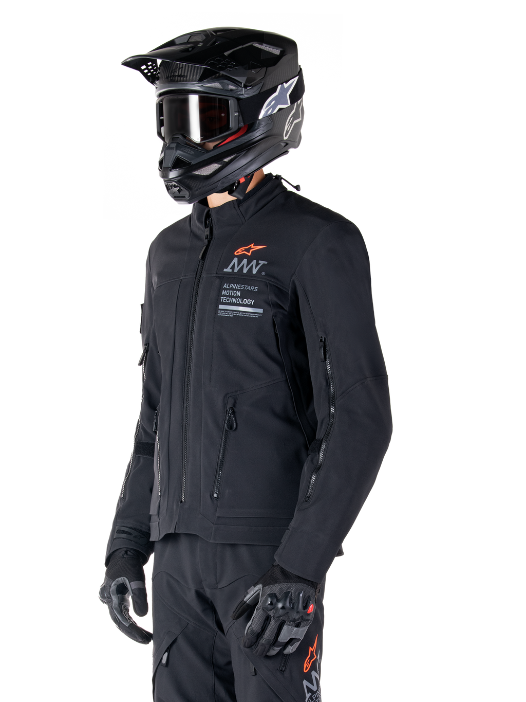 Casaco Alpinestars AMT-8 Stretch Drystar® XF, preto, usado por um motociclista com calças de aventura e luvas a condizer, incluindo capacete de motocross preto e óculos, aberturas de ventilação com fecho no peito e nos braços, marca Alpinestars Motion Technology com logótipo laranja, equipamento premium de adventure-touring