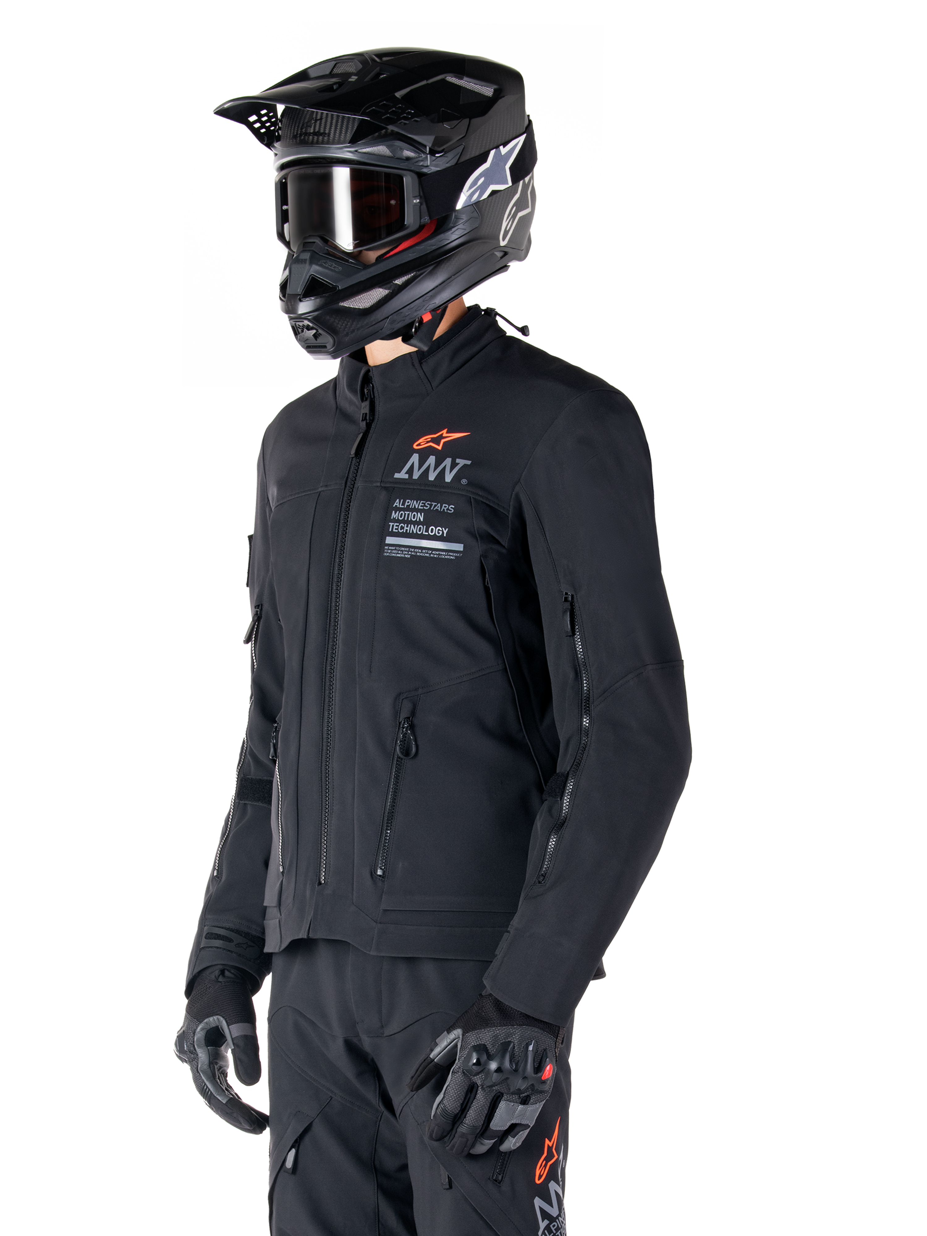 Casaco Alpinestars AMT-8 Stretch Drystar® XF, preto, usado por um motociclista com calças de aventura e luvas a condizer, incluindo capacete de motocross preto e óculos, aberturas de ventilação com fecho no peito e nos braços, marca Alpinestars Motion Technology com logótipo laranja, equipamento premium de adventure-touring