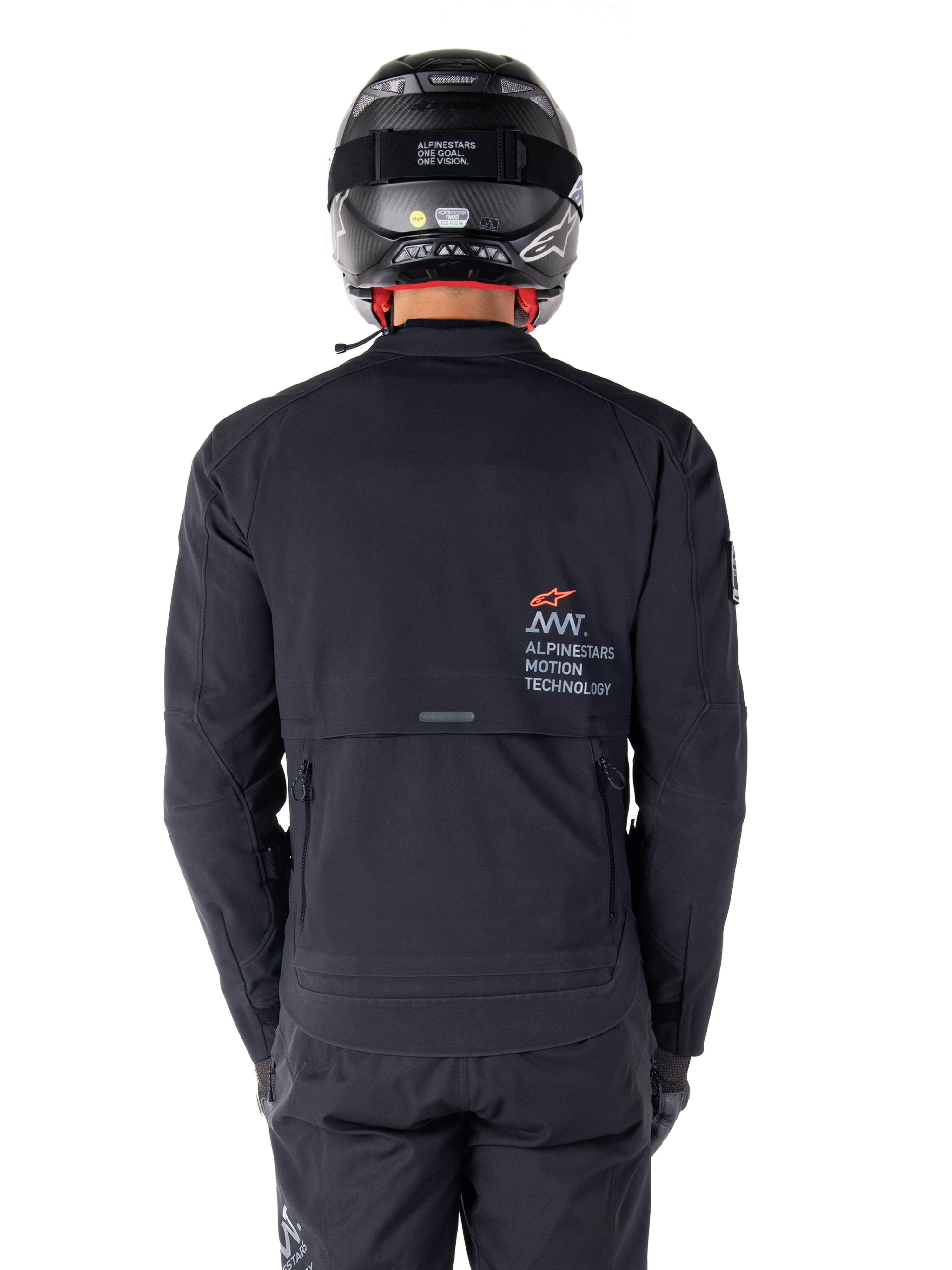 Casaco Alpinestars AMT-8 Stretch Drystar® XF, vista traseira, preto, usado com capacete e calças pretas, com logótipo Alpinestars Motion Technology nas costas, design de touring de aventura com material elástico ergonómico.