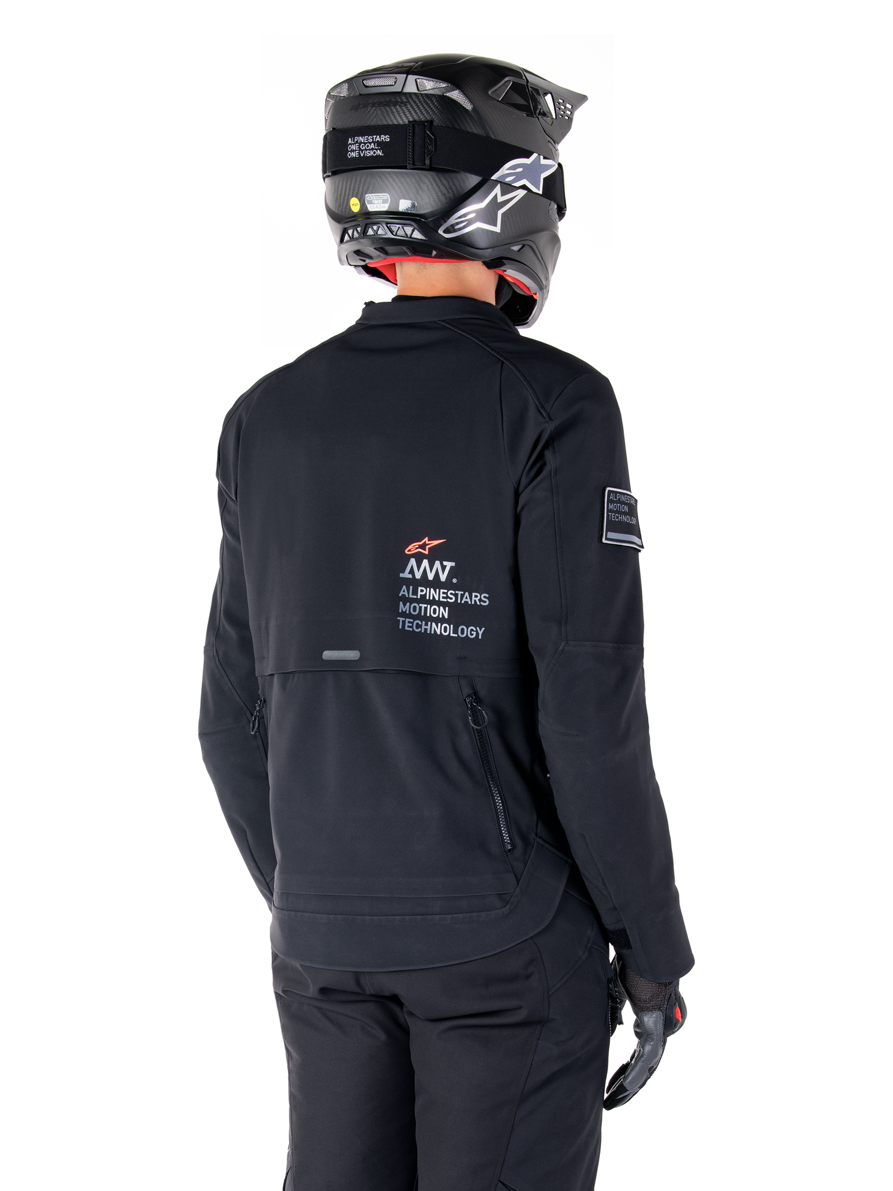 Vista traseira de um motociclista a usar o Casaco Alpinestars AMT-8 Stretch Drystar® XF em preto, com a marca 'AMT Alpinestars Motion Technology' nas costas, ventilação técnica com fecho de correr, combinado com um capacete e luvas de motociclismo pretos.