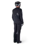Casaco Alpinestars AMT-8 Stretch Drystar® XF, preto, vista traseira de um motociclista a usar o casaco com calças pretas a condizer e um capacete preto, com a marca 'Alpinestars Motion Technology' nas costas, material elástico técnico para motociclismo de aventura