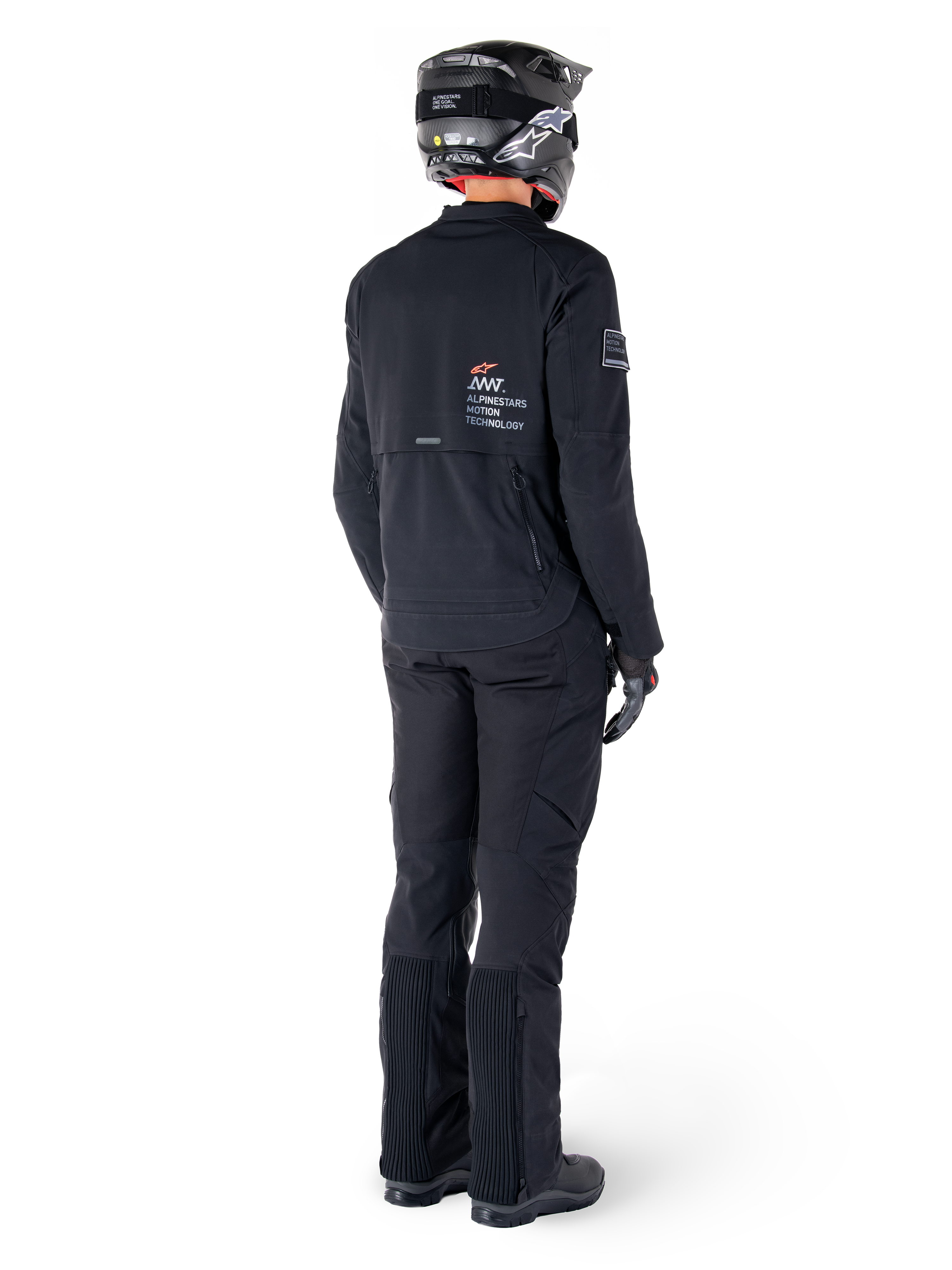 Casaco Alpinestars AMT-8 Stretch Drystar® XF, preto, vista traseira de um motociclista a usar o casaco com calças pretas a condizer e um capacete preto, com a marca 'Alpinestars Motion Technology' nas costas, material elástico técnico para motociclismo de aventura
