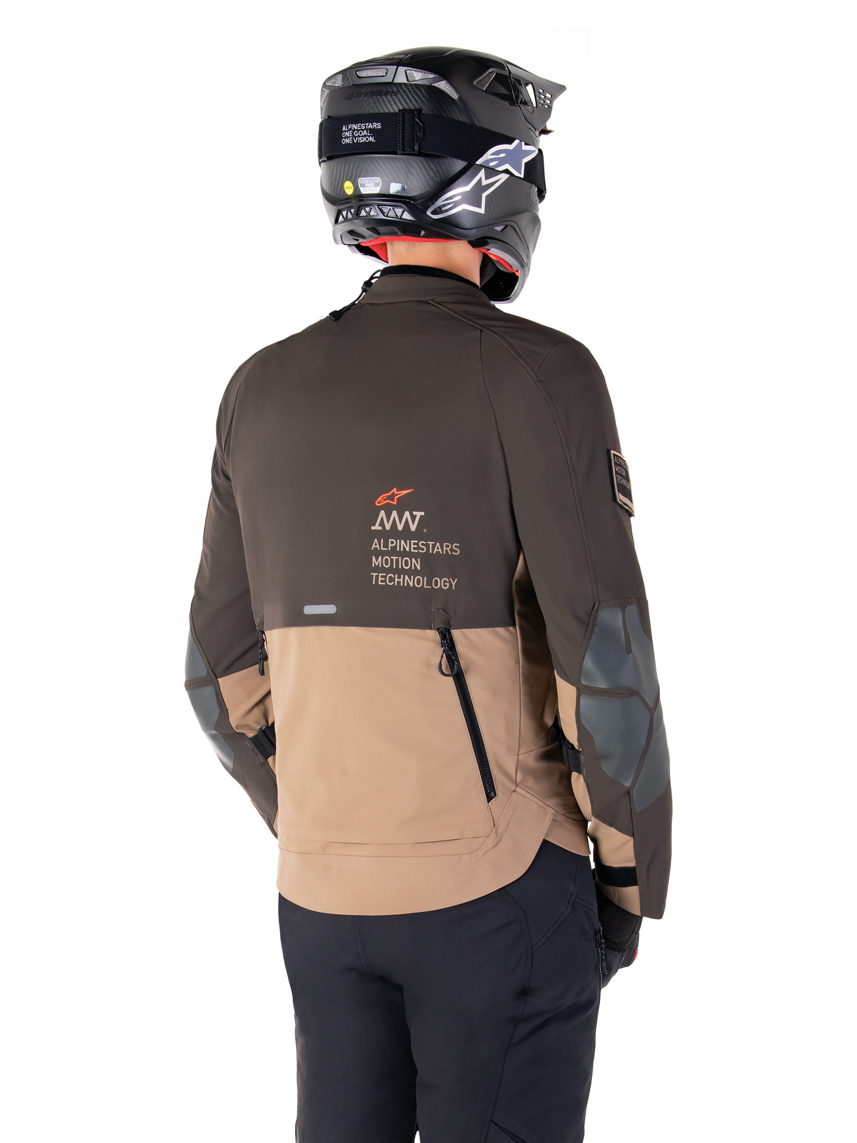 Alpinestars AMT-8 Stretch Drystar® XF Jacket, Adventure Motorcycle Jacket, Dark Brown and Dark Khaki, rear view showing AMT Alpinestars Motion Technology branding, two-tone textile design with back ventilation zippers and shingle-style exhaust, worn with black helmet and riding pants
