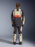 Casaco laminado Alpinestars Halo Pro Drystar® XF, casaco de motociclismo de aventura, Mastic Black com logótipo cor de laranja, vista traseira que mostra o logótipo grande nas costas e fechos de ventilação modulares, usado com calças de aventura a condizer para desempenho em todo-o-terreno