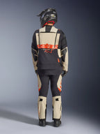 Alpinestars Halo Pro Drystar® XF Laminated Jacket, casaco de motociclismo de aventura, Mastic Black, vista traseira de um motociclista a usar calças a condizer e um capacete preto, com o logótipo Alpinestars em laranja vibrante e painéis de ventilação modulares para uma condução de aventura versátil.