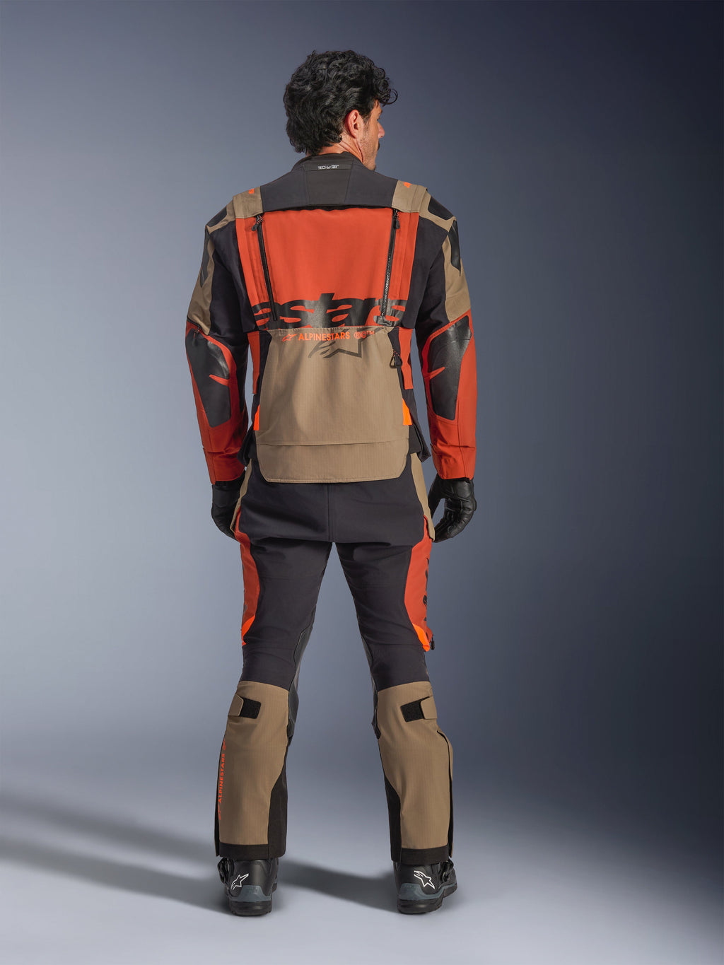 Alpinestars Halo Pro Drystar® XF Laminated Jacket, Walnut Rust Black, vista traseira, casaco de aventura touring com design modular e grande bolso traseiro impermeável, usado com calças técnicas a condizer.