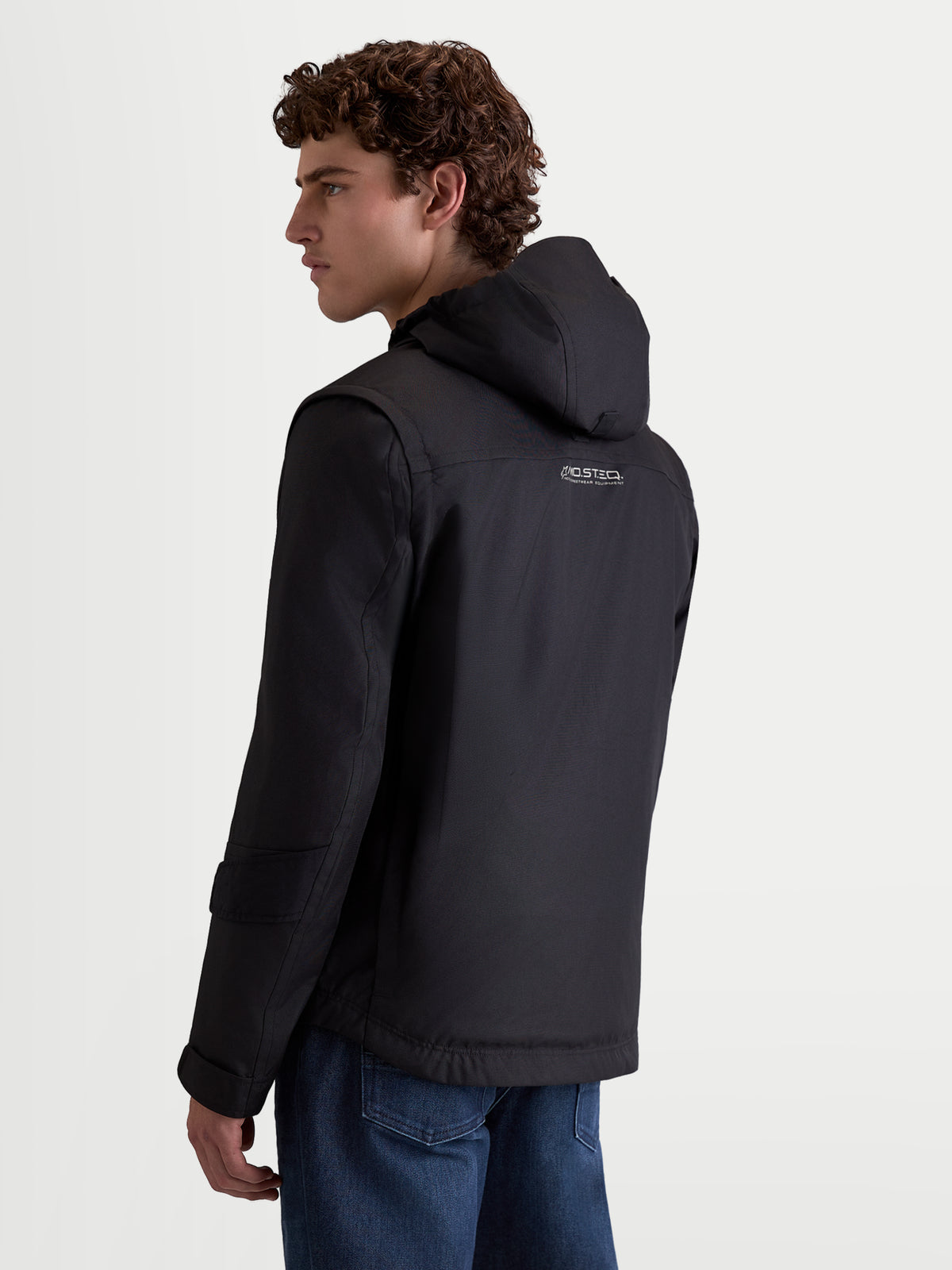 Alpinestars Morfex Parka Waterproof Jacket, casaco de moto urbano para homem, preto, vista traseira num modelo a usar o casaco têxtil com capuz integrado