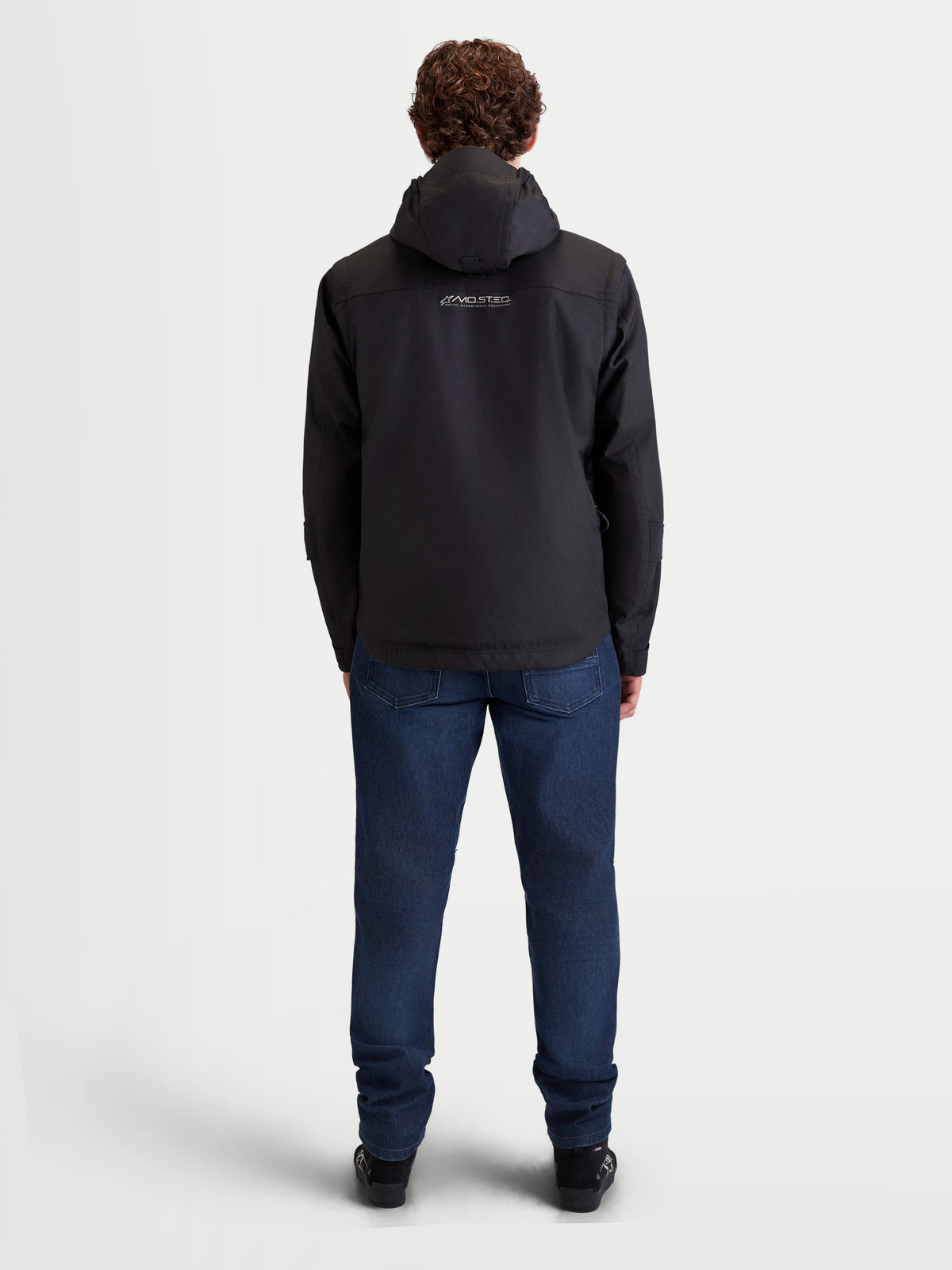 Alpinestars Morfex Parka Wp Jkt, casaco impermeável de moto para homem, preto, vista traseira num modelo a usar o casaco com capuz integrado e calças de ganga