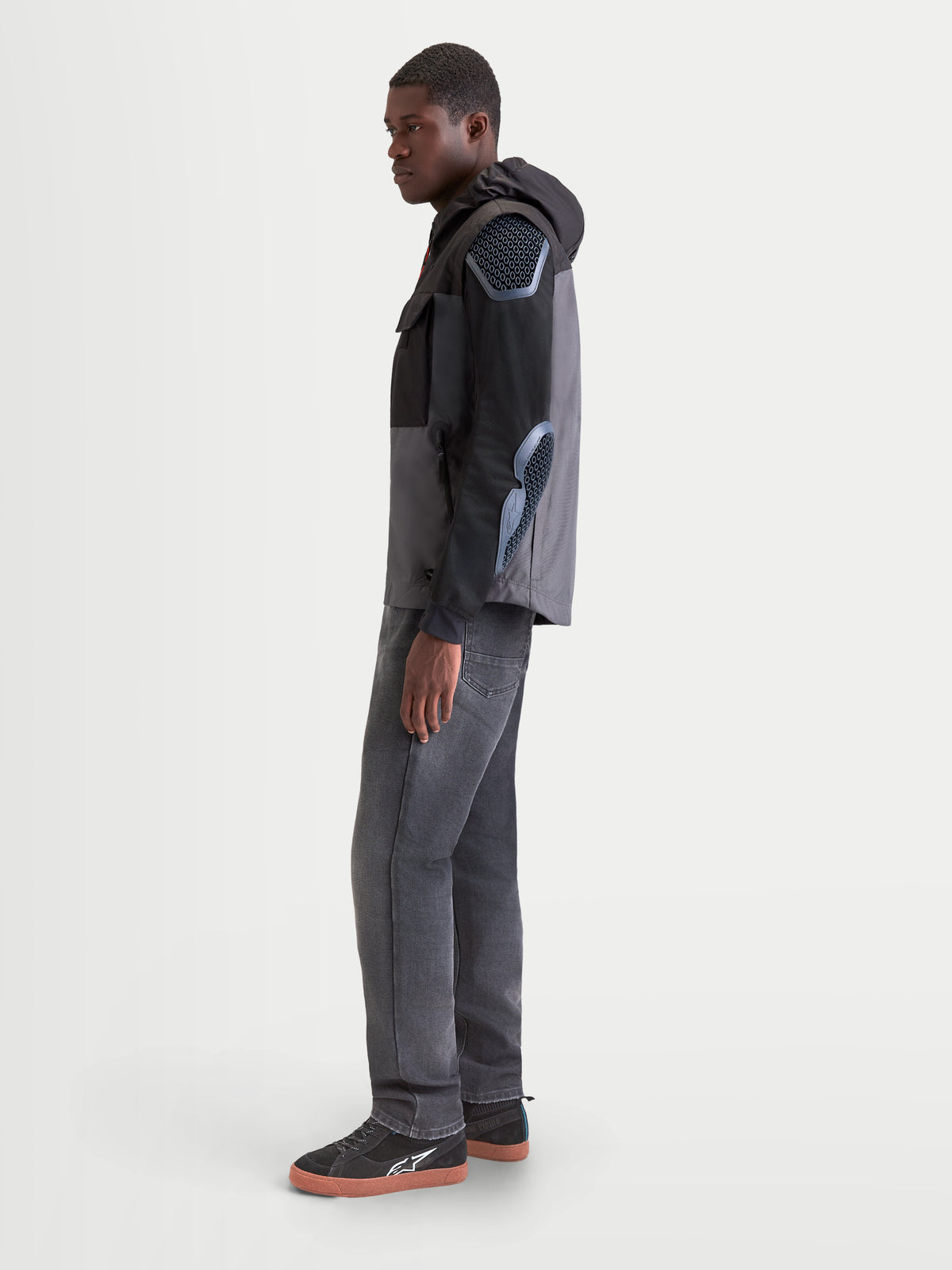 Alpinestars Morfex Parka casaco impermeável de moto para homem, cinzento e preto, vista de perfil lateral num modelo a usar o blusão têxtil com capuz integrado
