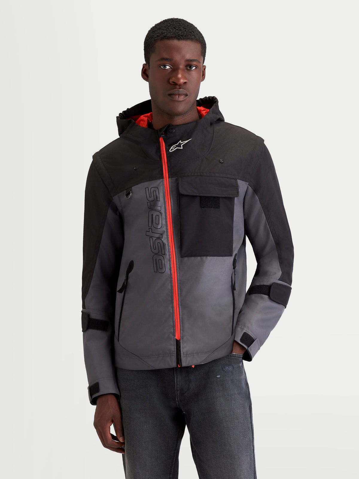 Alpinestars Morfex Parka casaco de moto impermeável para homem, cinzento e preto, vista frontal num modelo com fecho frontal laranja contrastante e capuz integrado