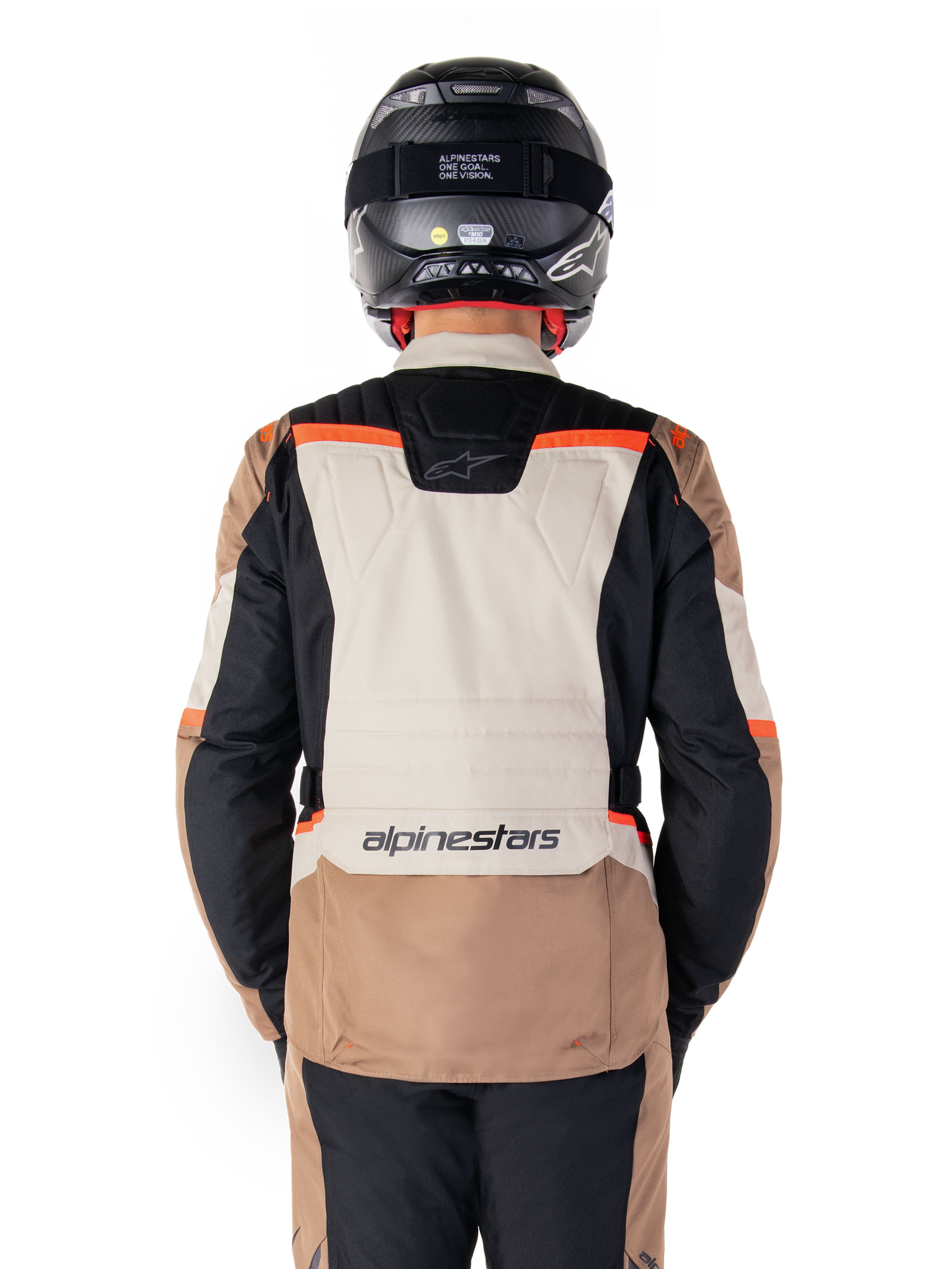 Casaco Alpinestars ST-1 Impermeável, Dark Khaki Sand Black Red Fluo, vista posterior, casaco de motociclismo de turismo de aventura com um grande painel traseiro cor de areia, mangas pretas e pormenores em vermelho fluorescente, mostrado num motociclista com um capacete preto.