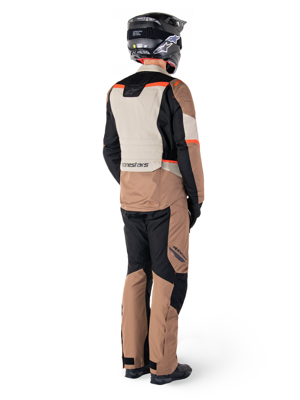 Casaco Impermeável Alpinestars ST-1, casaco de turismo de aventura, Dark Khaki Sand Black Red Fluo, vista traseira, usado com calças a condizer e capacete preto, com painéis em blocos de cores e detalhes em vermelho fluorescente.