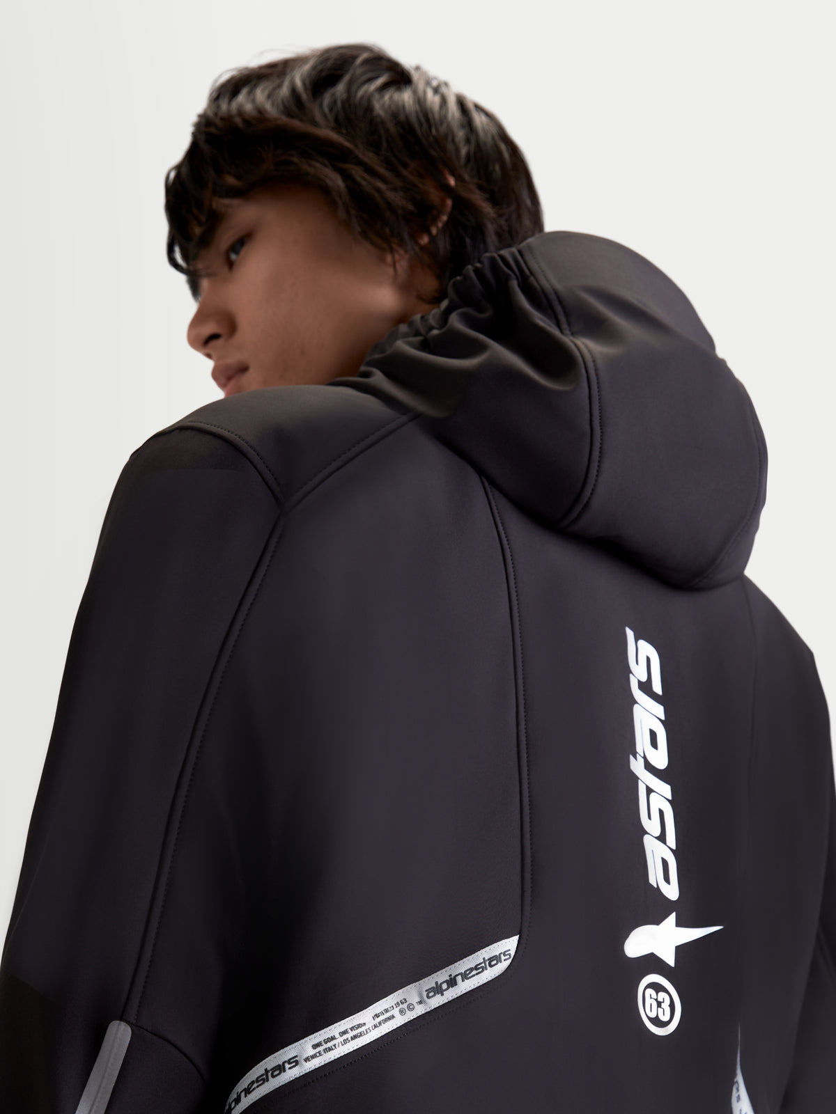 Alpinestars C 5 Drystar casaco, casaco de moto urbano contemporâneo para homem, preto, vista traseira próxima a mostrar o capuz integrado e detalhes refletores da marca num modelo
