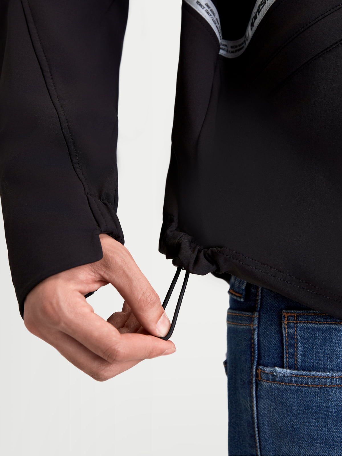 Alpinestars C 5 Drystar casaco, casaco de moto urbano têxtil para homem, preto, vista em pormenor a mostrar o ajuste do cordão elástico na bainha inferior e punho elástico