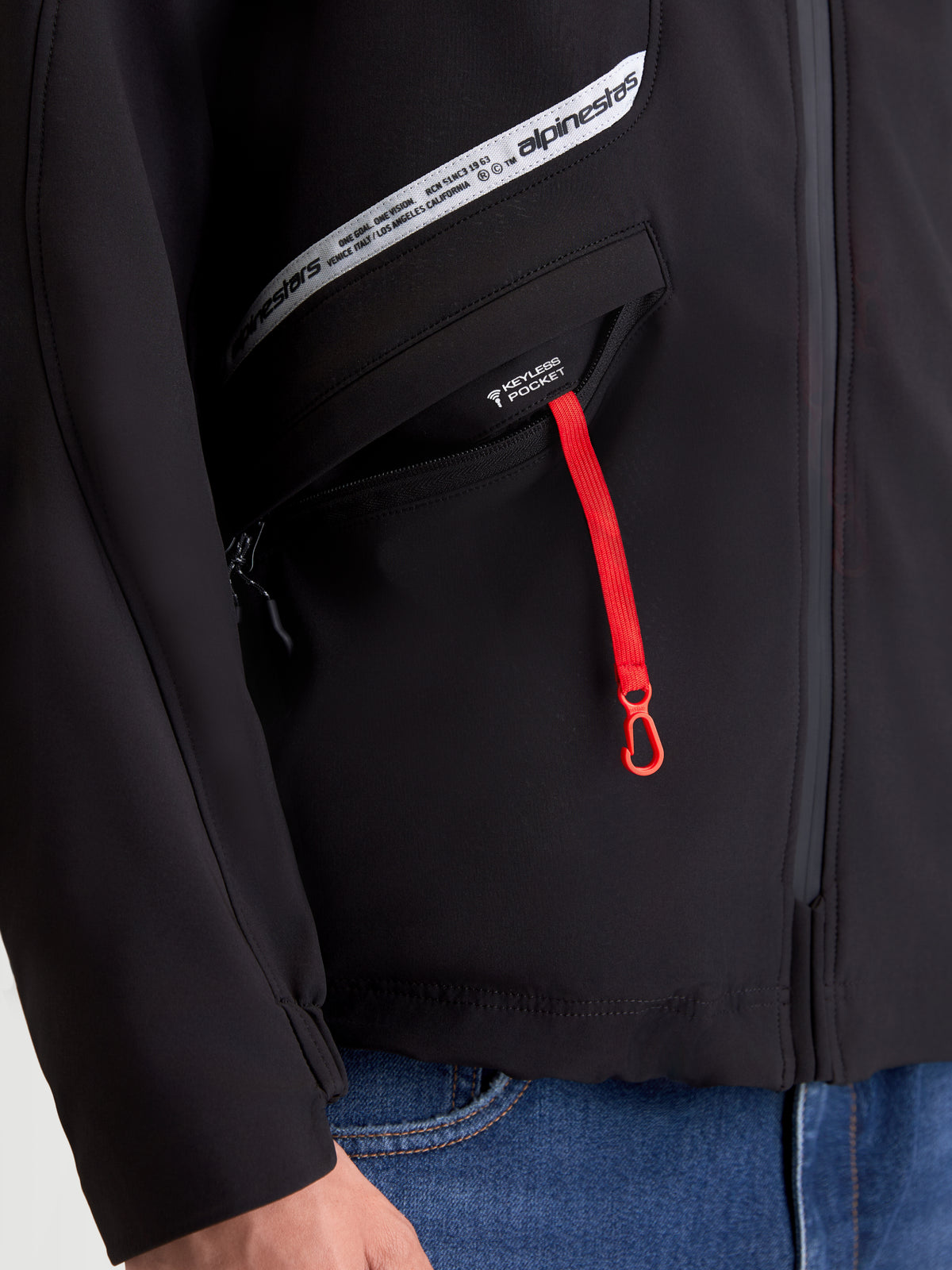 Alpinestars C-5 Drystar casaco de moto urbano para homem, preto, vista em pormenor do bolso com fecho de correr vermelho e gráfico da marca no peito