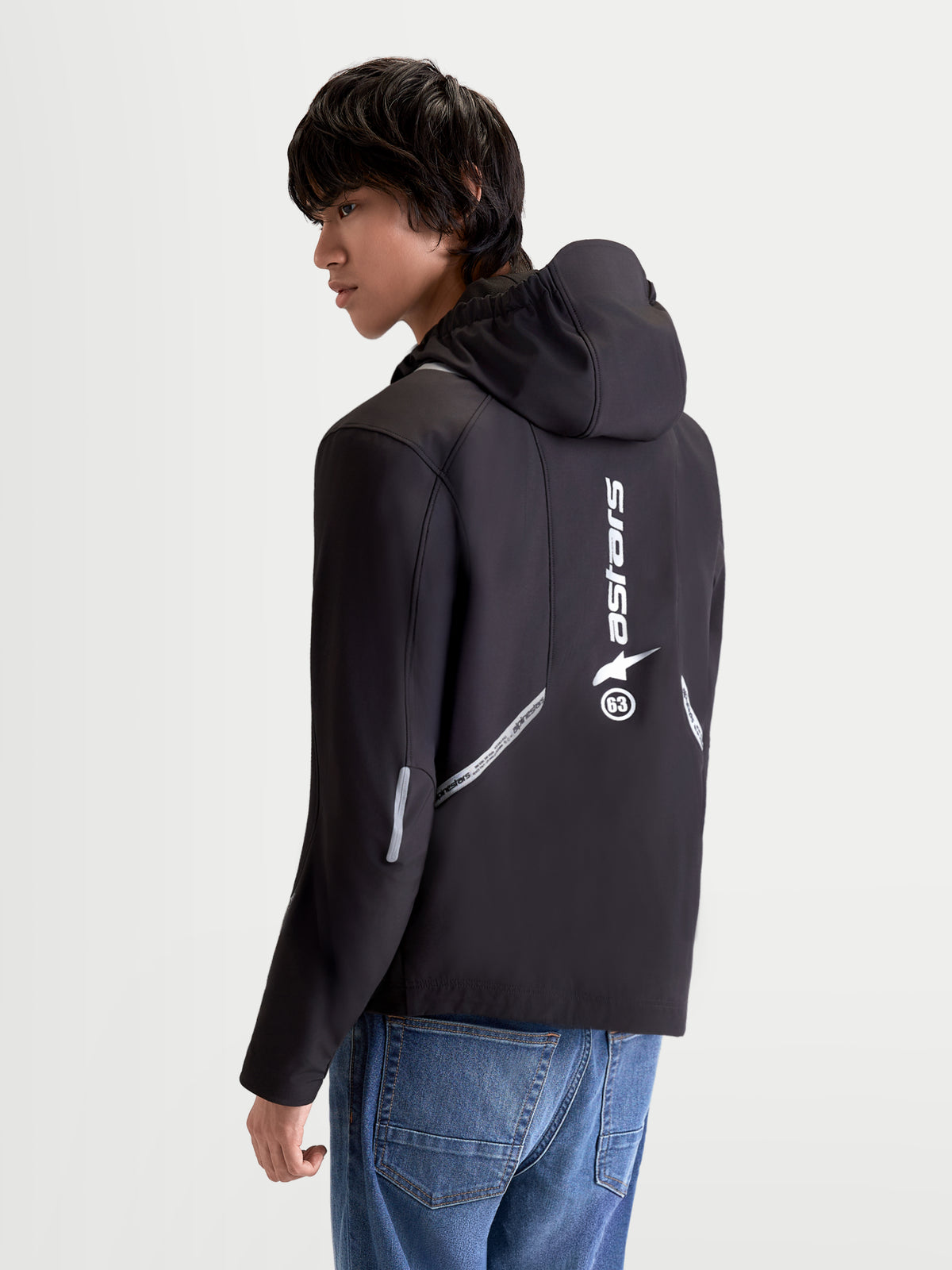 Alpinestars C 5 Drystar casaco de moto urbano para homem, preto, vista traseira de três quartos num modelo a mostrar capuz integrado, detalhes refletores e logótipo vertical nas costas