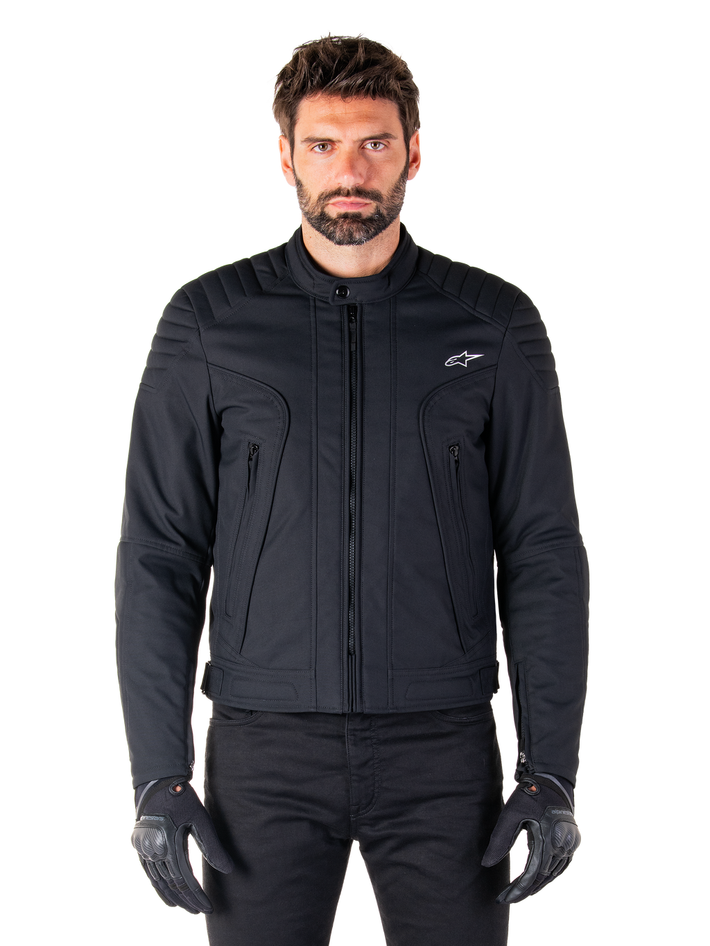 Casaco Alpinestars Clayton WR, casaco de motociclismo preto, vestido por modelo, com detalhes acolchoados nos ombros e grafismos técnicos, fecho de correr Vislon central, bolsos verticais com fecho de correr, pequeno logótipo branco no peito, equipamento de condução urbana para uso em estrada
