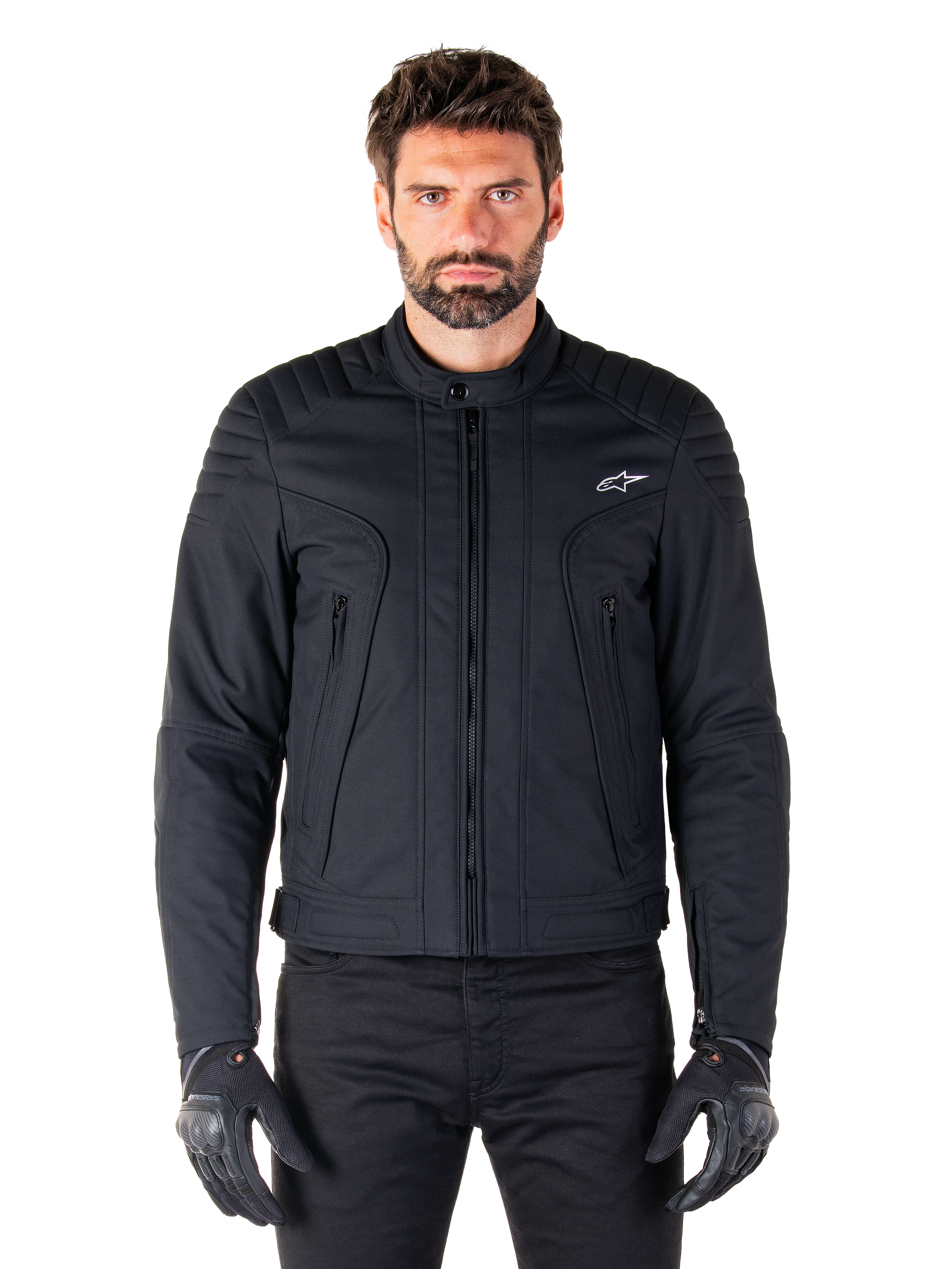 Casaco Alpinestars Clayton WR, casaco de motociclismo preto, vestido por modelo, com detalhes acolchoados nos ombros e grafismos técnicos, fecho de correr Vislon central, bolsos verticais com fecho de correr, pequeno logótipo branco no peito, equipamento de condução urbana para uso em estrada