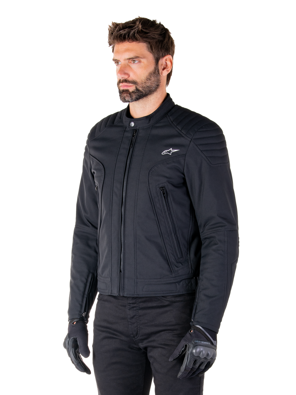 Casaco Alpinestars Clayton WR, preto, casaco de motociclista urbano em tecido com detalhes acolchoados nos ombros e antebraços, design de corte slim, acabamento fosco, usado por um motociclista com luvas pretas