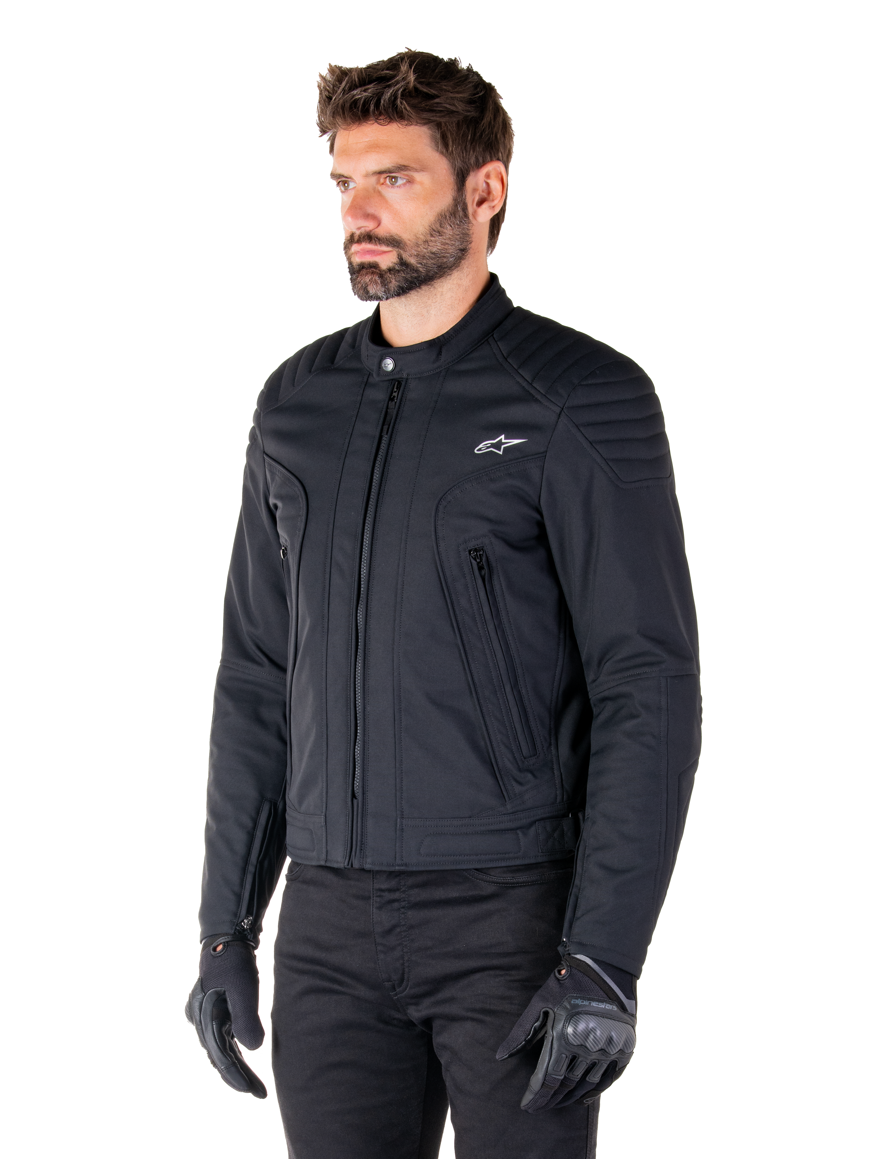 Casaco Alpinestars Clayton WR, preto, casaco de motociclista urbano em tecido com detalhes acolchoados nos ombros e antebraços, design de corte slim, acabamento fosco, usado por um motociclista com luvas pretas