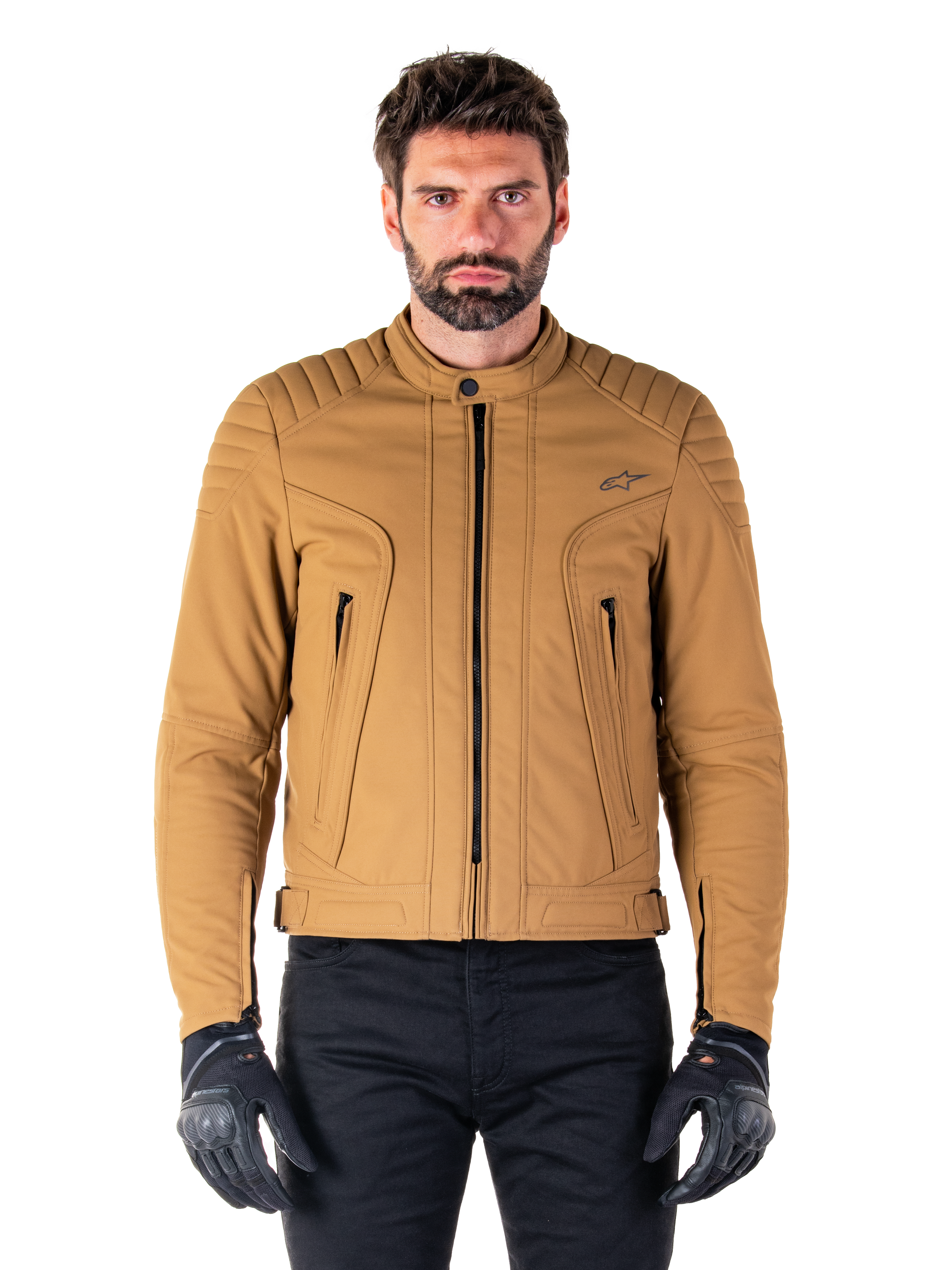 Alpinestars Clayton WR Jacket, casaco de motociclismo urbano, castanho e dourado claro, tecido têxtil resistente à água com ombros acolchoados, gola alta de motociclista, detalhes de fecho pretos e logótipo no peito, usado com luvas de proteção e calças pretas