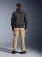Casaco Impermeável Alpinestars Moblast, preto, vista traseira de hoodie de motociclismo urbano, usado com calças cargo beges e sapatilhas pretas, design minimalista com branding 'astars' vertical na parte superior das costas, equipamento de condução contemporâneo para todas as condições climatéricas