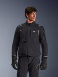 Alpinestars Andes Pro Drystar® XF Jacket, casaco de moto para turismo de aventura em preto e cinzento escuro, usado com calças e luvas a condizer, com construção técnica laminada, logótipo ALL TERRA no peito, detalhes refletores e punhos ajustáveis