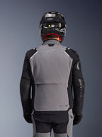 Alpinestars Andes Pro Drystar® XF Jacket, Dark Gray and Black, back view showing large rear storage pocket and Tech-Air branding, worn by a rider with a black helmet and matching riding pants, professional adventure touring gear