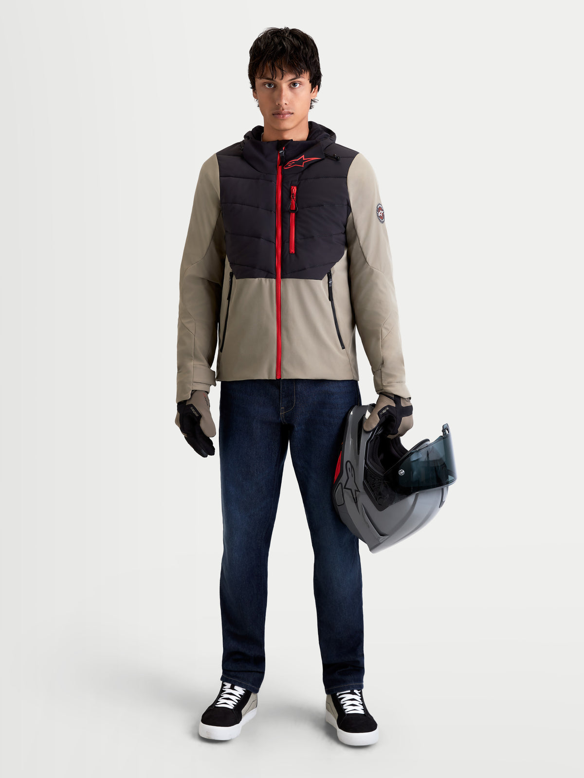 Alpinestars Therma Tech WP casaco, casaco de moto urbano contemporâneo para homem em preto e cinzento, vista frontal completa num modelo a usar luvas a combinar e a segurar um capacete, vestuário impermeável e térmico para condução em estrada