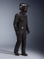 Alpinestars Cusco Drystar® Jacket, Black adventure touring motorcycle jacket, worn with matching black pants and a full-face helmet with goggles, featuring a functional multi-pocket design, technical textile construction, and Drystar branding on the sleeve.