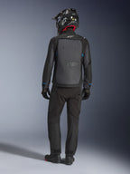 Casaco Alpinestars Cusco Drystar®, preto e cinzento escuro, vista traseira de um condutor com equipamento completo de touring de aventura, grande painel traseiro cinzento com o logótipo Alpinestars, detalhes azuis nas mangas, usado com calças pretas a condizer e capacete.