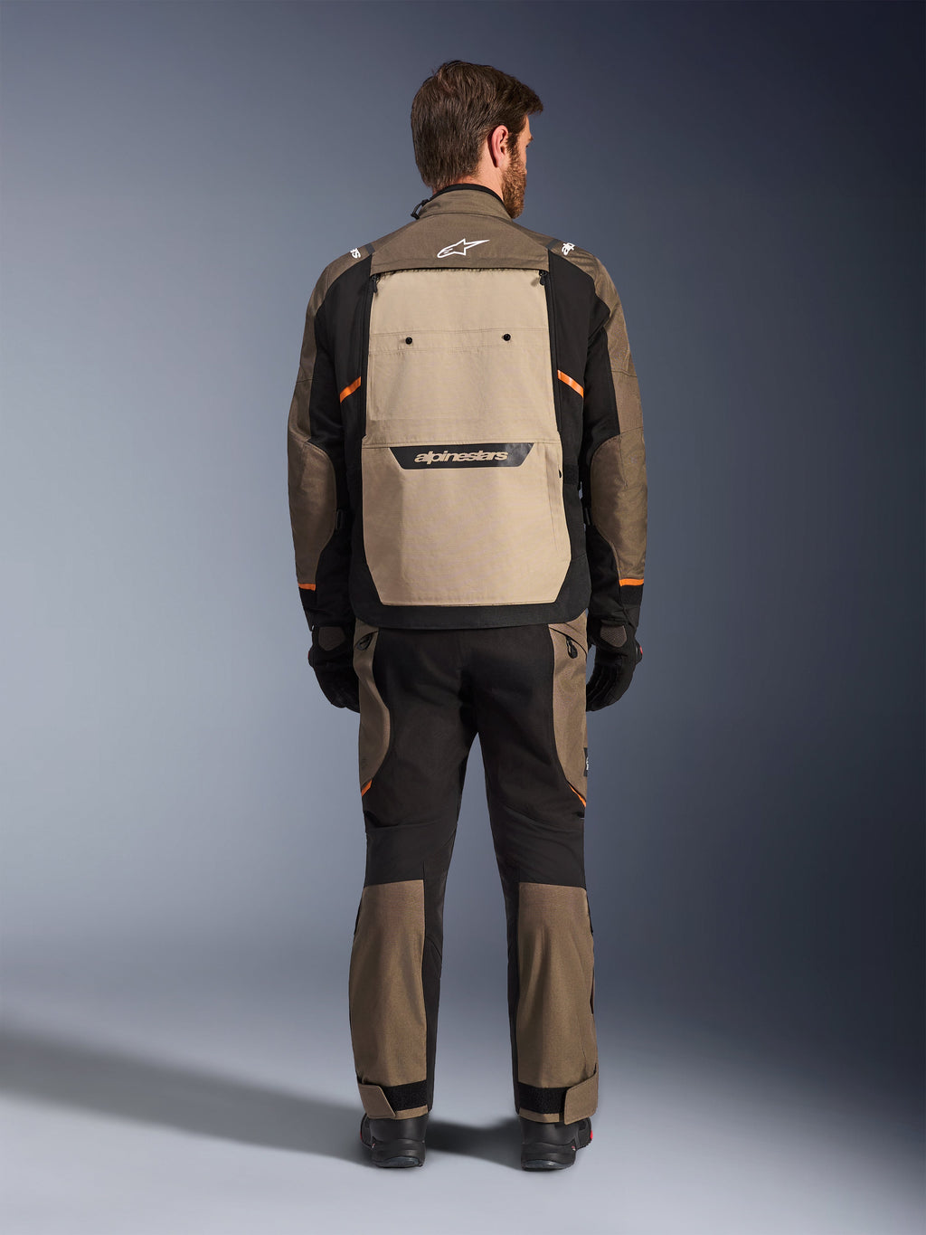 Casaco Alpinestars Cusco Drystar®, vista traseira, Walnut Aluminum Black, equipamento têxtil de aventura e touring, painel de ventilação traseiro grande em bege com logótipo preto, detalhes em laranja, usado com calças e luvas a condizer