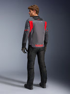 Male rider from behind wearing the Alpinestars St-2 Air Jacket in Deep Gray, Dark Gray and Bright Red, showcasing the large mesh ventilation panel on the back and red branding, styled with black motorcycle pants and gray gloves.