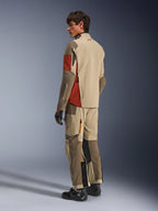 Male model wearing the Alpinestars Maxdura Drystar®XF Laminated Armored Shell in Aluminum Walnut Rust Brown, matching adventure touring pants, black gloves, and black boots, back view showing the technical textile construction and reinforced zones.