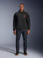Alpinestars Revved WR Jacket in Black, worn by a model with dark blue jeans and black sneakers, front view, featuring snap button closure and a 3D embroidered logo on the chest, urban contemporary motorcycle gear.