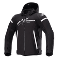 Casaco Alpinestars Zaca Waterproof, casaco de motociclismo preto com capuz removível, logótipo Alpinestars grande em branco no peito, riscas brancas na parte superior dos braços e detalhes laterais verticais, fecho de correr frontal, proteção reforçada nos ombros, correias ajustáveis na cintura e nos braços, construção em tecido softshell