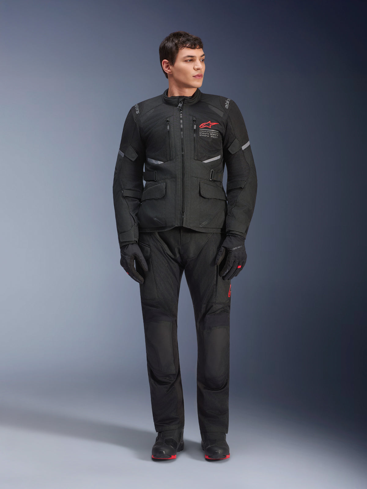 Alpinestars Andes Air Drystar® Pants, calças de motociclismo para turismo, pretas, com painéis de ventilação em malha e logótipo vermelho na perna, usadas como parte de um equipamento de condução completo com casaco e luvas a condizer, equipamento profissional de adventure touring
