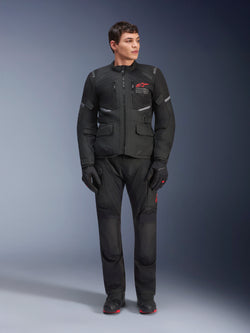 Alpinestars Andes Air Drystar® Pants, calças de motociclismo para turismo, pretas, com painéis de ventilação em malha e logótipo vermelho na perna, usadas como parte de um equipamento de condução completo com casaco e luvas a condizer, equipamento profissional de adventure touring