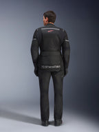 Casaco e Calças Alpinestars Andes Air Drystar®, equipamento de touring para motociclismo em preto, vista traseira do piloto, com painéis em malha, logótipo de estrela vermelha e marca Alpinestars refletora no casaco, usado com luvas e botas pretas