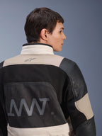 Casaco Alpinestars AMT-10LAB Drystar® XF, vista traseira num modelo masculino, cores White Sand Aluminum Camo e preto, com logótipo AMT de grandes dimensões, painéis de ventilação em malha e reforços em couro, vestuário técnico de motociclismo de aventura