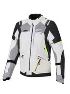 Casaco Alpinestars Stella Andes V4 Drystar® para Mulher, casaco de aventura e turismo para mulher, cinza gelo e cinza escuro com detalhes em preto e amarelo néon, construção têxtil durável com fechos de correr impermeáveis e logótipo Alpinestars, vista frontal