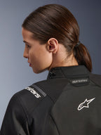 Alpinestars Casaco Feminino Stella Andes V4 Drystar®, preto, vista detalhada da parte superior das costas e ombro, com logótipo Astar e marca bordados a branco, construção em têxtil técnico para motociclismo de aventura