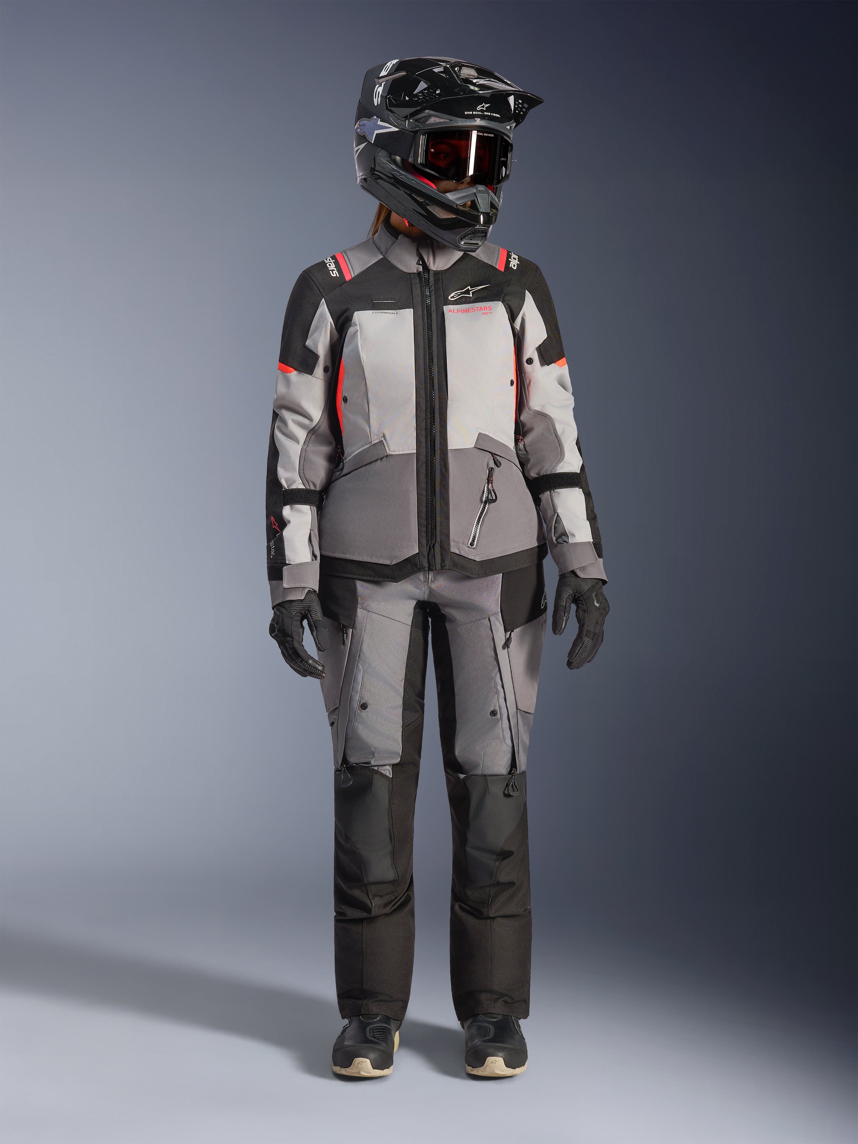 Alpinestars Stella Andes V4 Drystar®, casaco de moto adventure para mulher, cinzento e coral fluo, com calças a condizer.